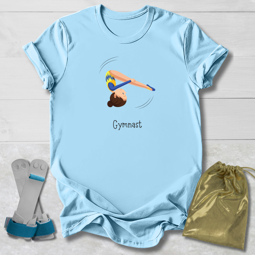Light blue t-shirt with gymnast design and text, paired with socks and a drawstring bag on a light wooden surface.