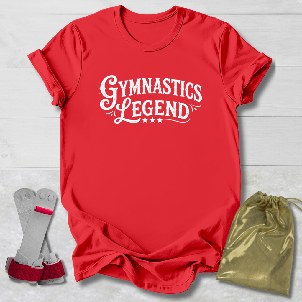 Red t-shirt with 'Gymnastics Legend' text, socks, and drawstring bag on a light wooden surface