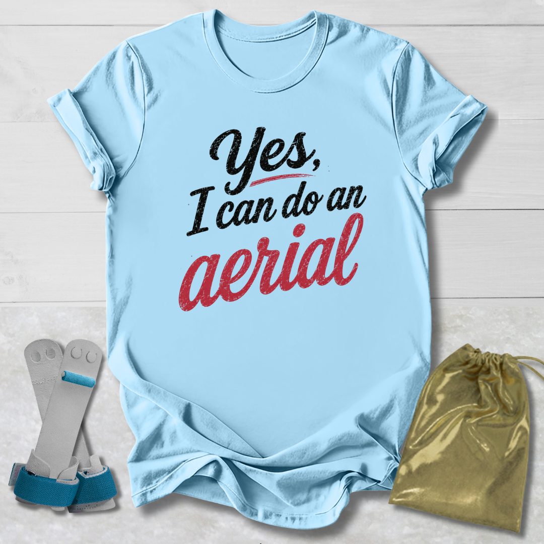 Light blue t-shirt with 'Yes, I can do an aerial' text, socks, and drawstring bag on a wooden surface.