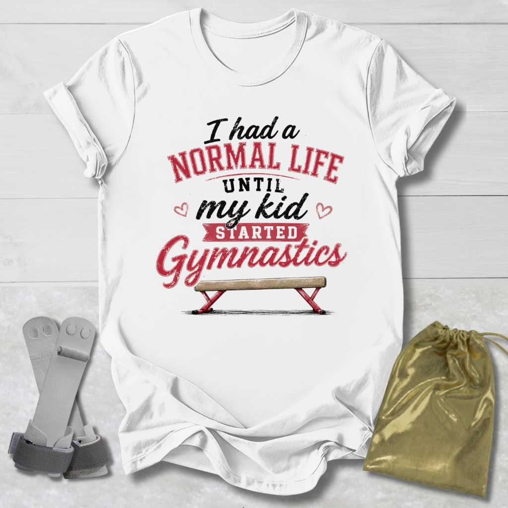 White t-shirt with humorous gymnastics text design on a light wooden surface with socks and a drawstring bag.