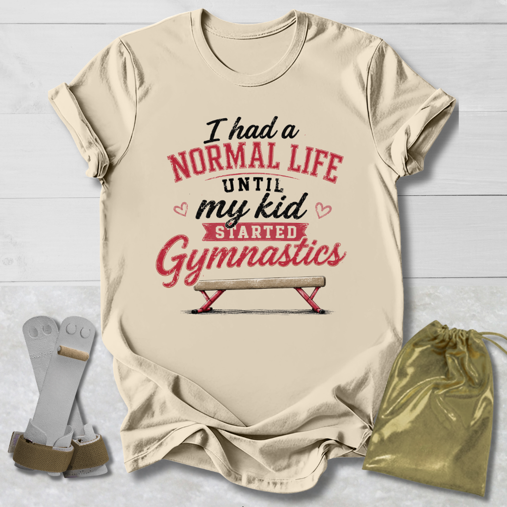 Beige t-shirt with humorous gymnastics text, socks, and drawstring bag on a light wooden surface