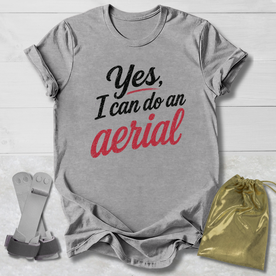 Gray t-shirt with 'Yes, I can do an aerial' text, socks, and drawstring bag on a light wooden surface