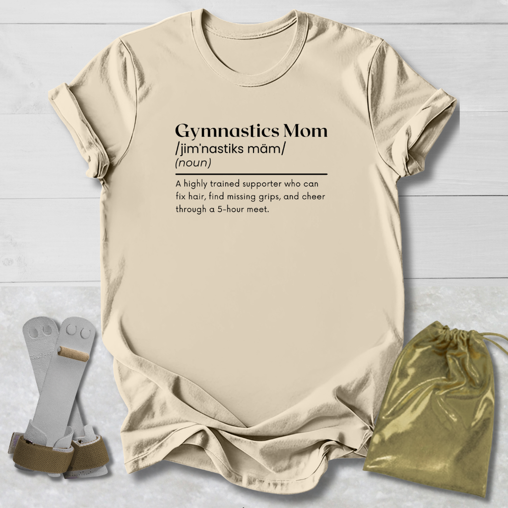 Beige t-shirt with 'Gymnastics Mom' definition text, socks, and drawstring bag on a light wooden surface.