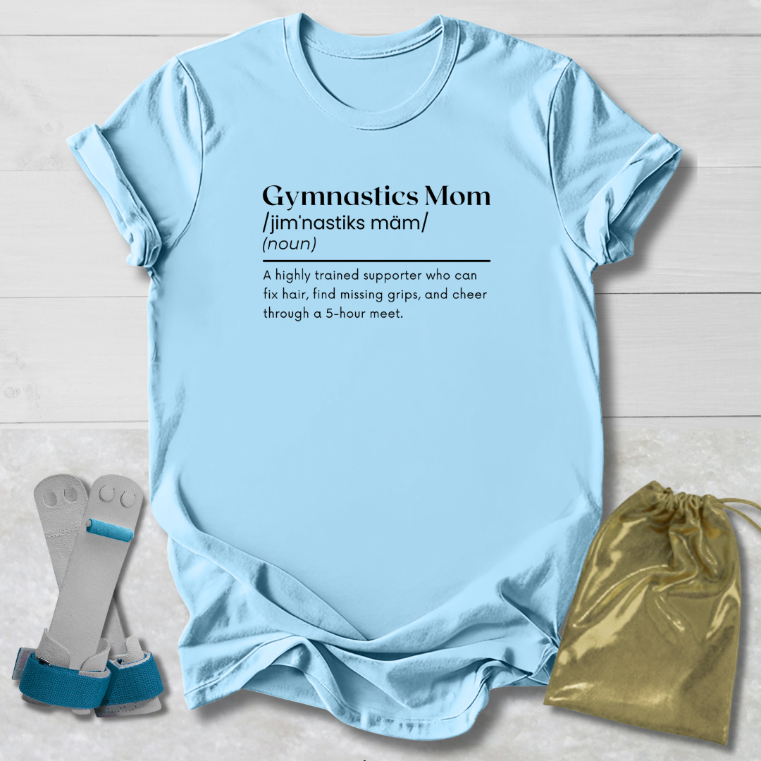 Light blue t-shirt with 'Gymnastics Mom' definition text, socks, and drawstring bag on a light wooden surface.