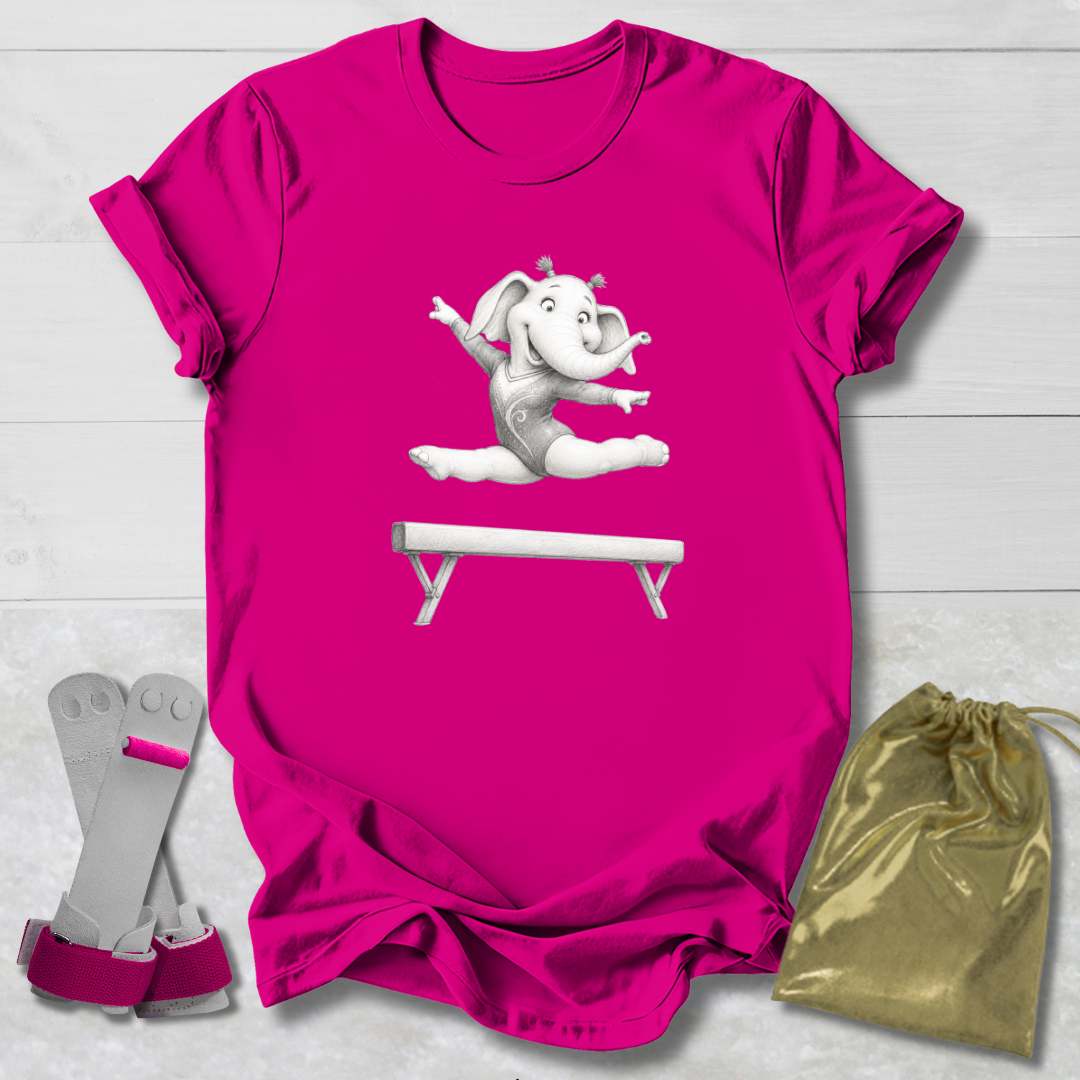 Pink t-shirt with a cartoon elephant on a balance beam, socks, and a drawstring bag on a light wooden surface.