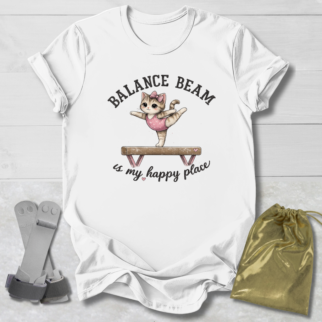 White t-shirt with a graphic of a cat on a balance beam and text, placed on a light wooden surface with socks and a drawstring bag.