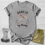 Gray t-shirt with a graphic of a cat on bars and text 'BARS IS my therapy' on a wooden surface.