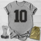 Gray t-shirt with number 10, socks, and drawstring bag on a light wooden surface