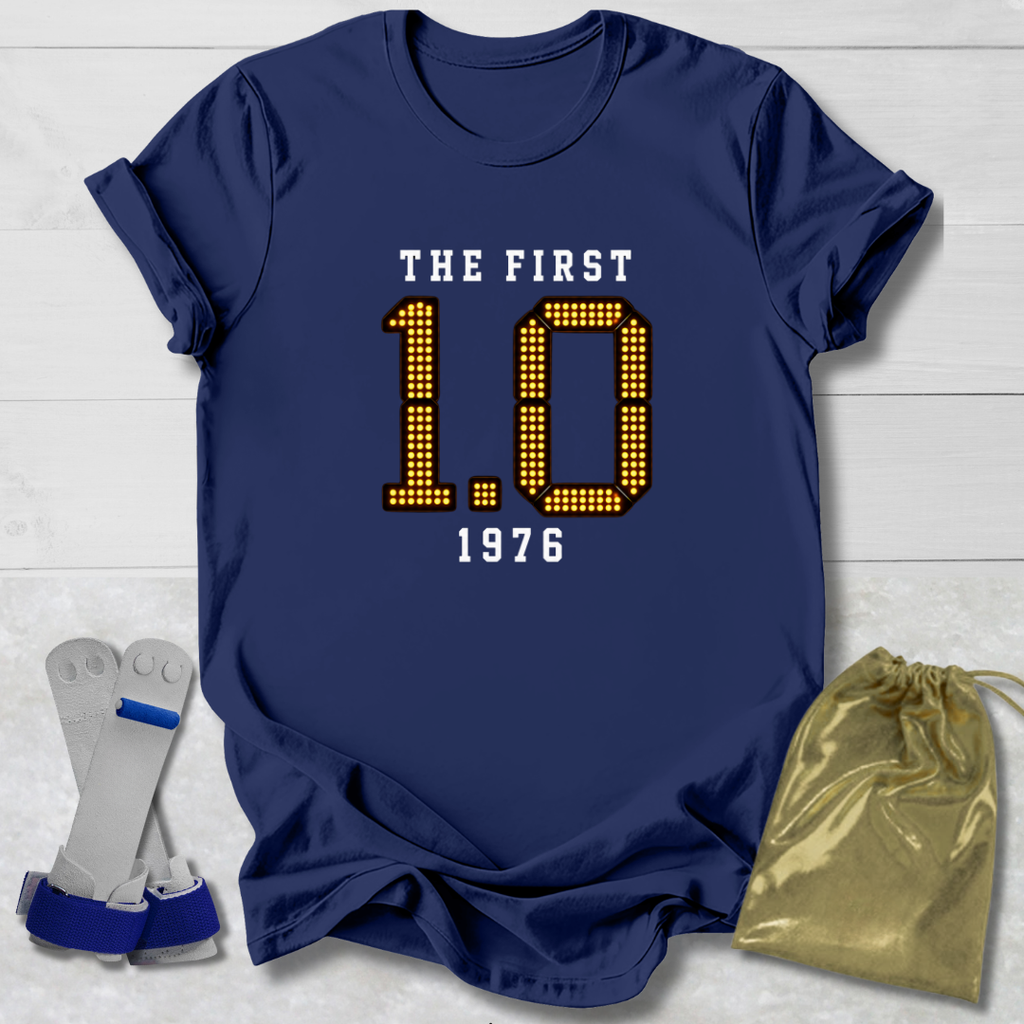 Navy blue t-shirt with 'The First 1.0 1976' text, socks, and drawstring bag on a light wooden surface.