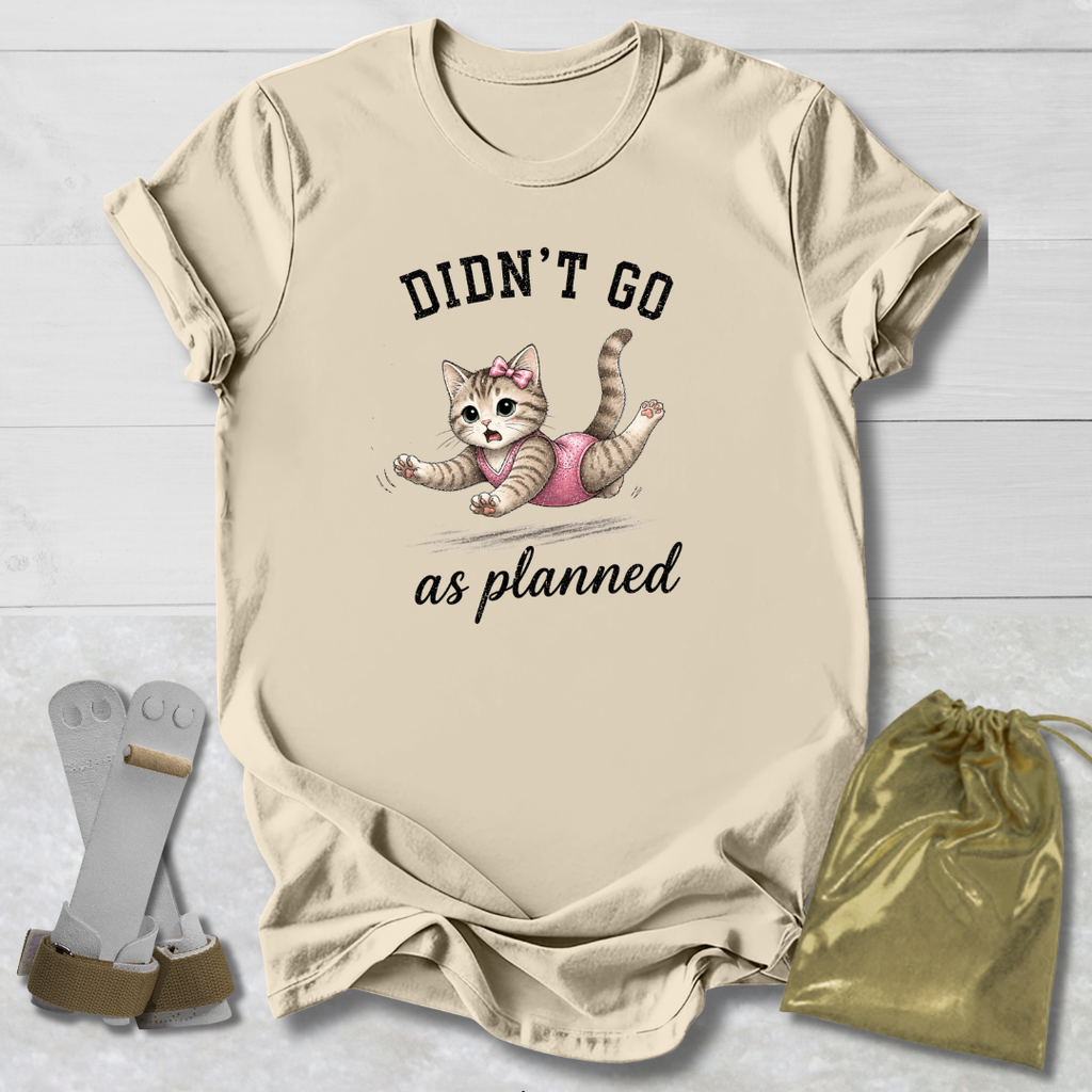 Beige t-shirt with a cat graphic and text, socks, and drawstring bag on a light wooden surface