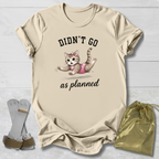 Beige t-shirt with a cat graphic and text, socks, and drawstring bag on a light wooden surface