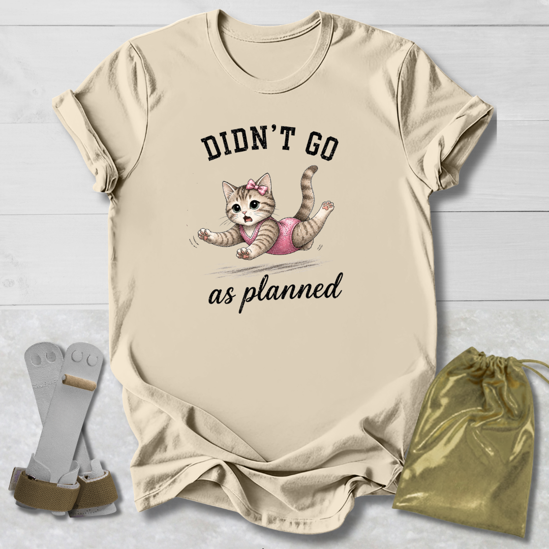 Beige t-shirt with a cat graphic and text, socks, and drawstring bag on a light wooden surface