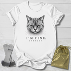 White t-shirt with a cat graphic and text 'I'm Fine. Gymnast' on a light wooden surface.