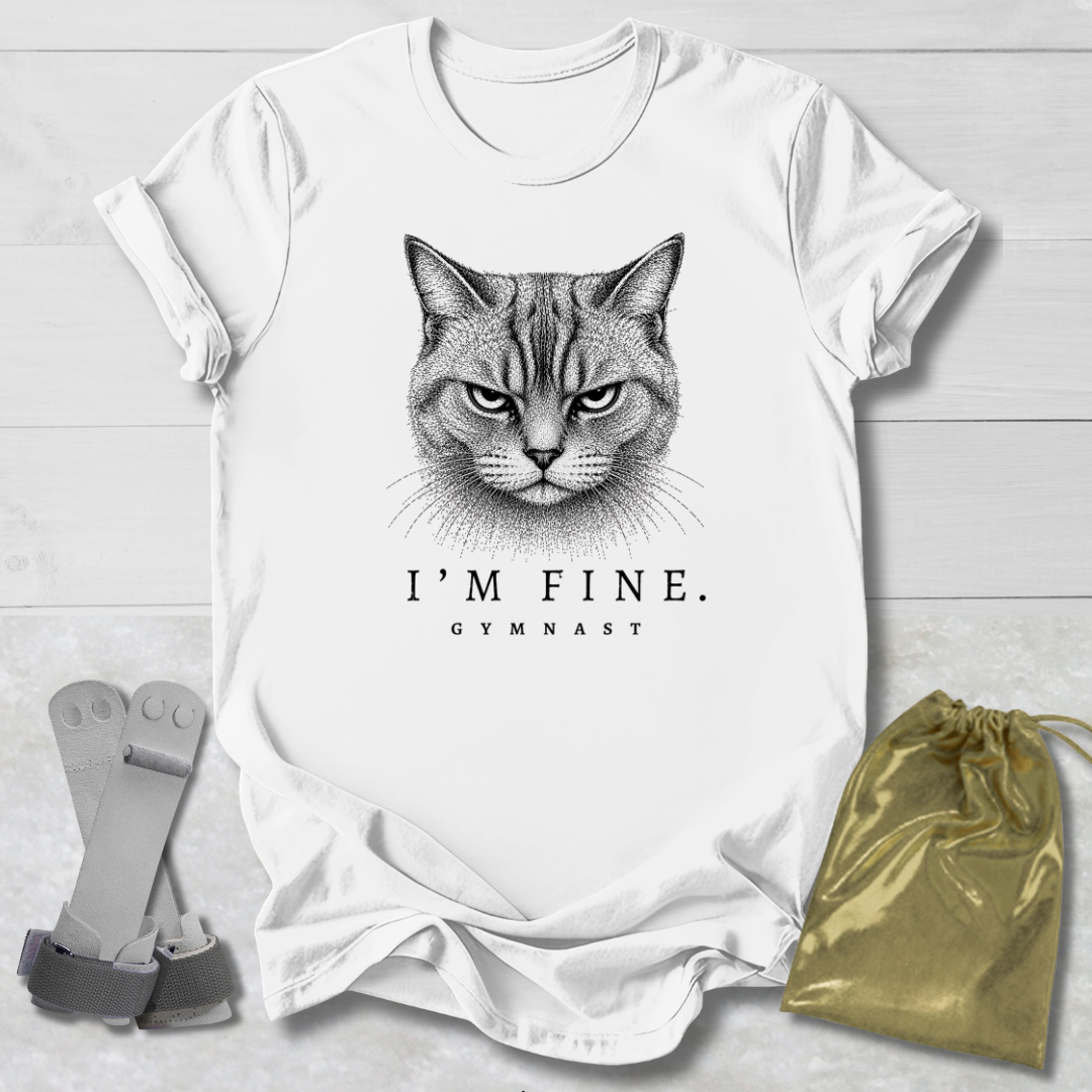 White t-shirt with a cat graphic and text 'I'm Fine. Gymnast' on a light wooden surface.