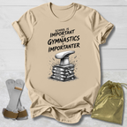 Beige t-shirt with gymnastics-themed text and graphic, socks, and drawstring bag on a light wooden surface.