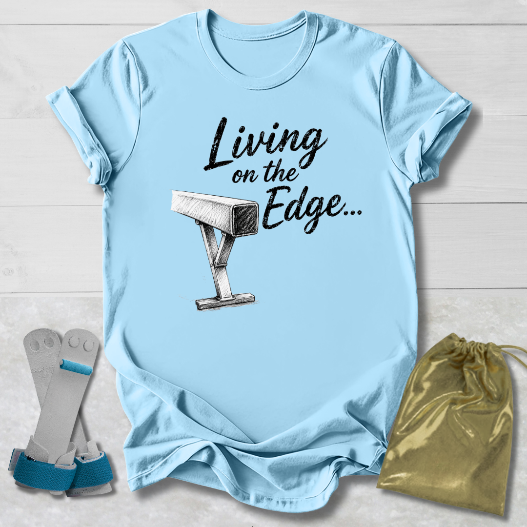 blue graphic T-shirt laid flat on a white wood background, printed with the words 'Living on the Edge.