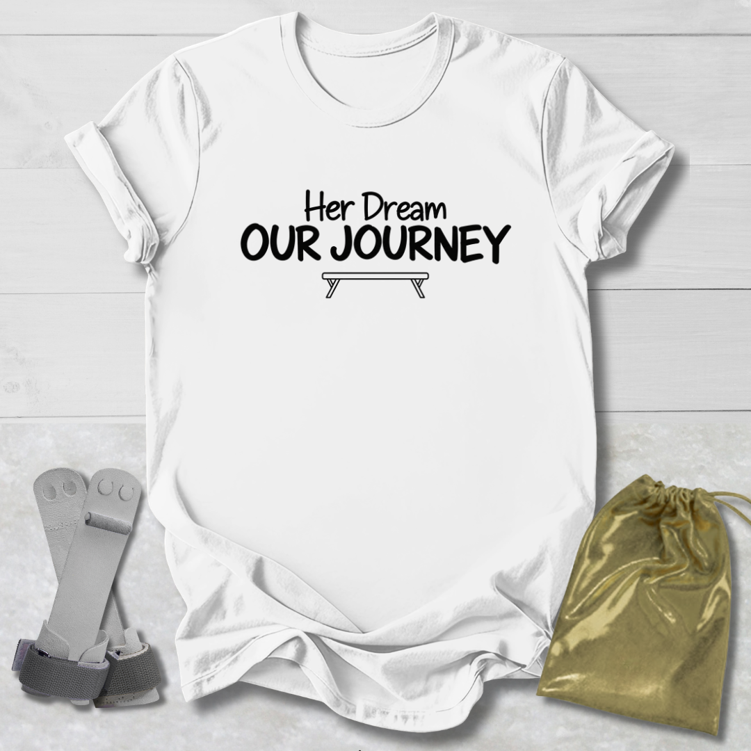 A white short-sleeve T-shirt laid flat on a light wood background, printed with the black text 'Will trade brother for a new leopard' across the chest. Two small accessories are placed beside it: a pair of gray straps on the left and a shiny gold drawstring pouch on the right.